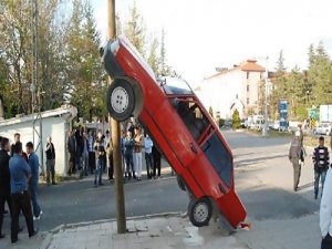 OTOMOBİL TELEFON DİREĞİNE ÇIKTI